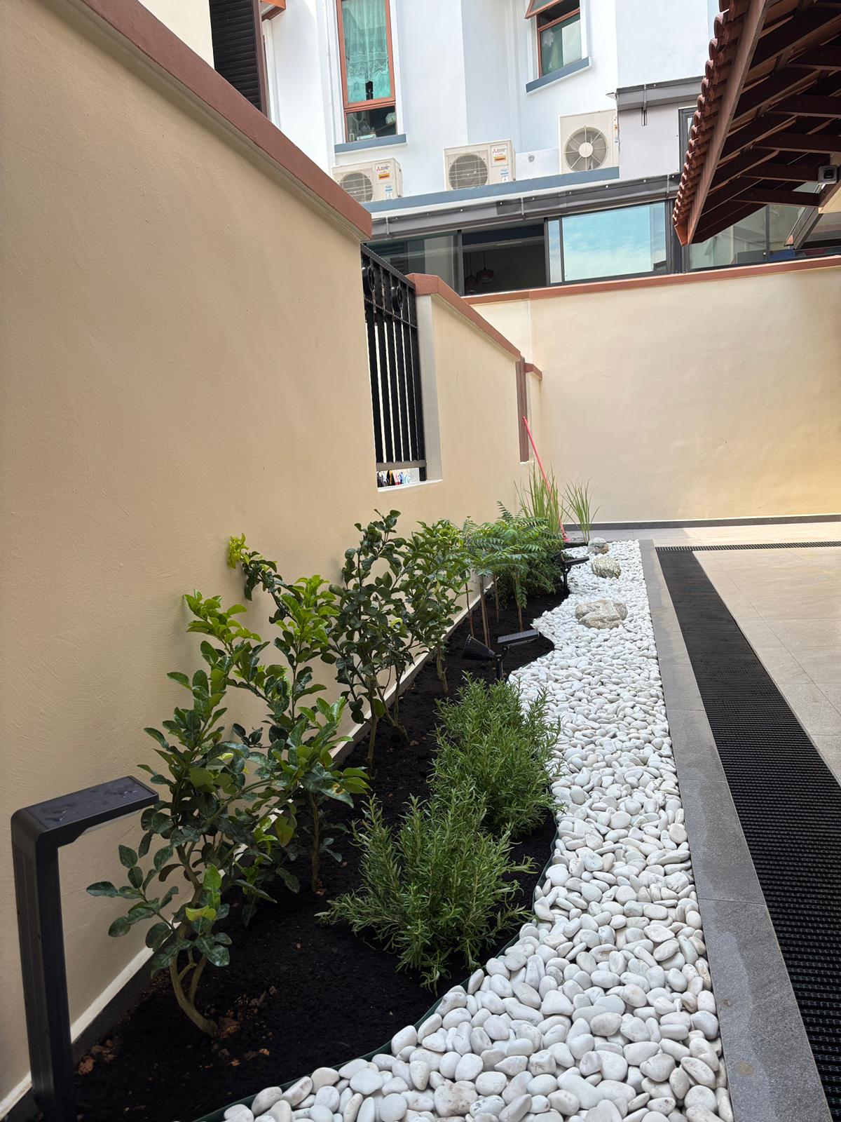 Residential garden installation with white pebbles and tropical plants