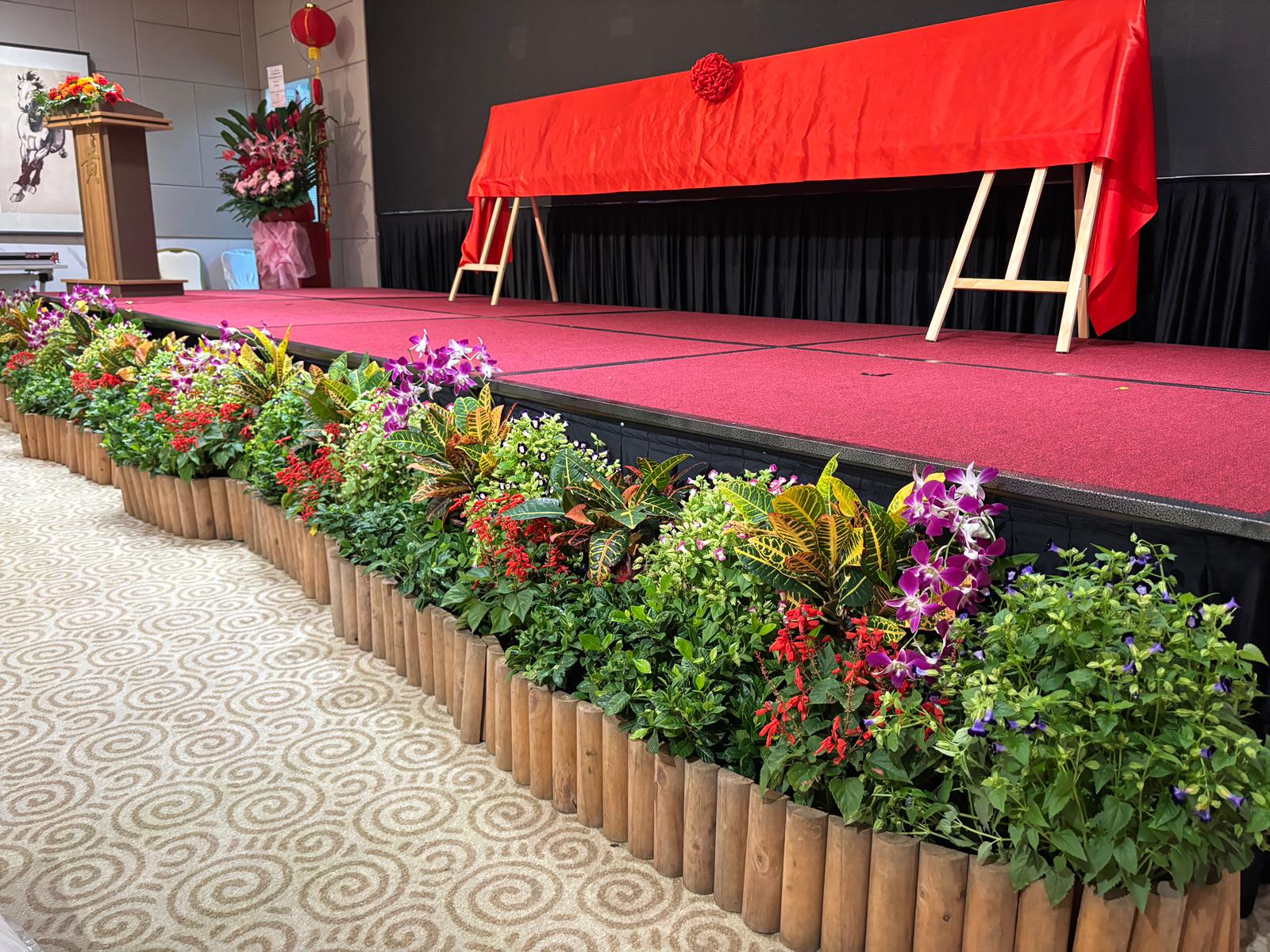 Event stage flanked by bamboo log planters
